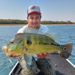 pescador segurando um tucunaré