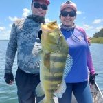 casal de pescadores segurando um tucunaré