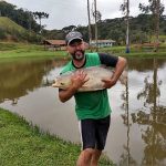 pescador segurando uma carpa nas mãos