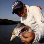 pescador mostrando a boca de um peixe chamado robalo peva