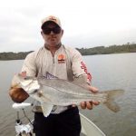 pescador segurando um grande robalo peva