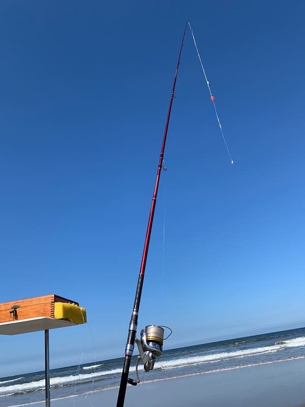 foto de uma vara de pesca com a chumbada bem próxima da ponteira da vara